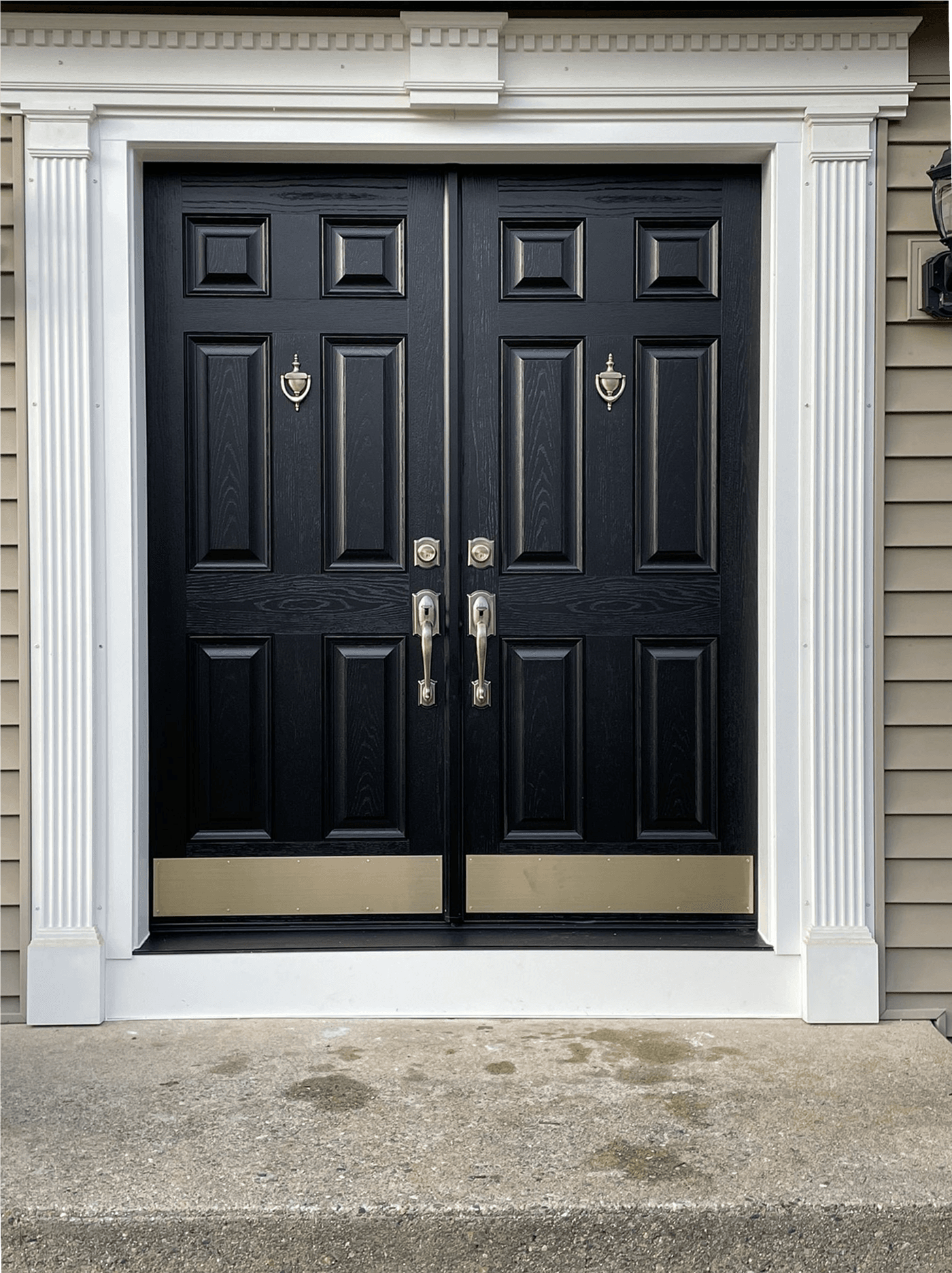 Newly-installed black double French entry doors.