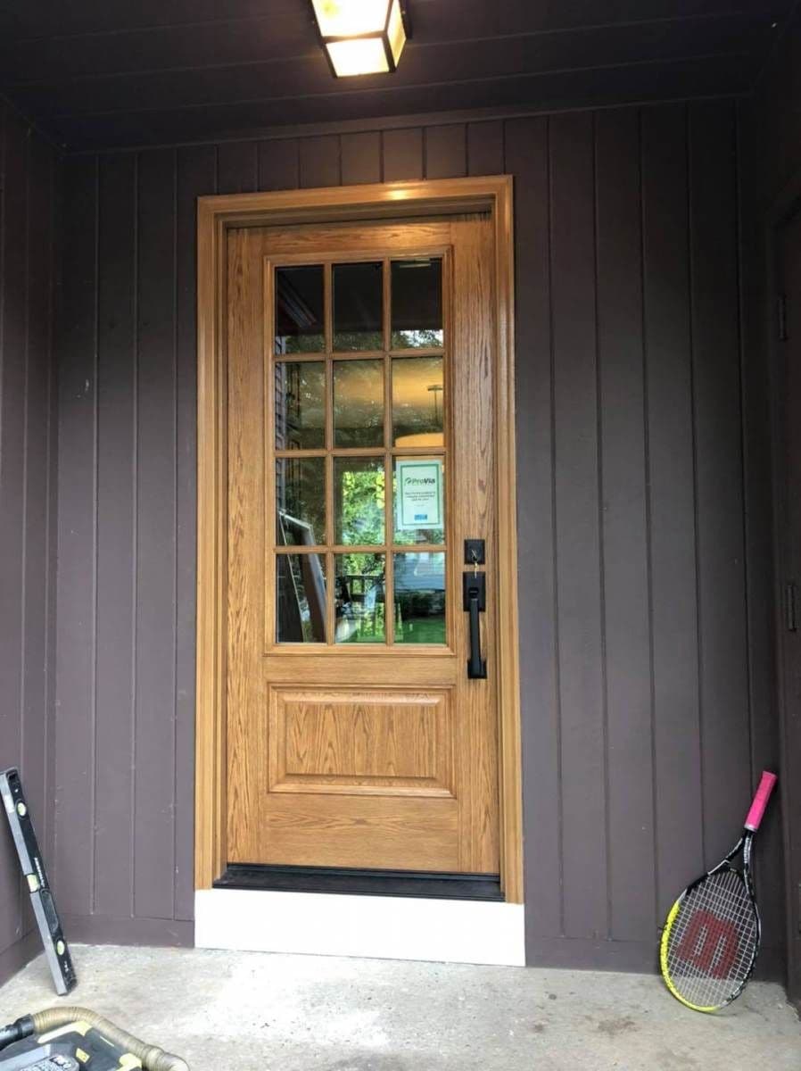 A brown fiberglass entry door made to look as if it is wood.