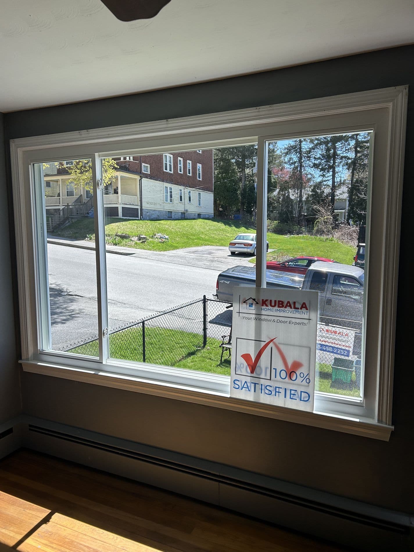 A large sliding window with a "100% Satisfied" sign in one corner.